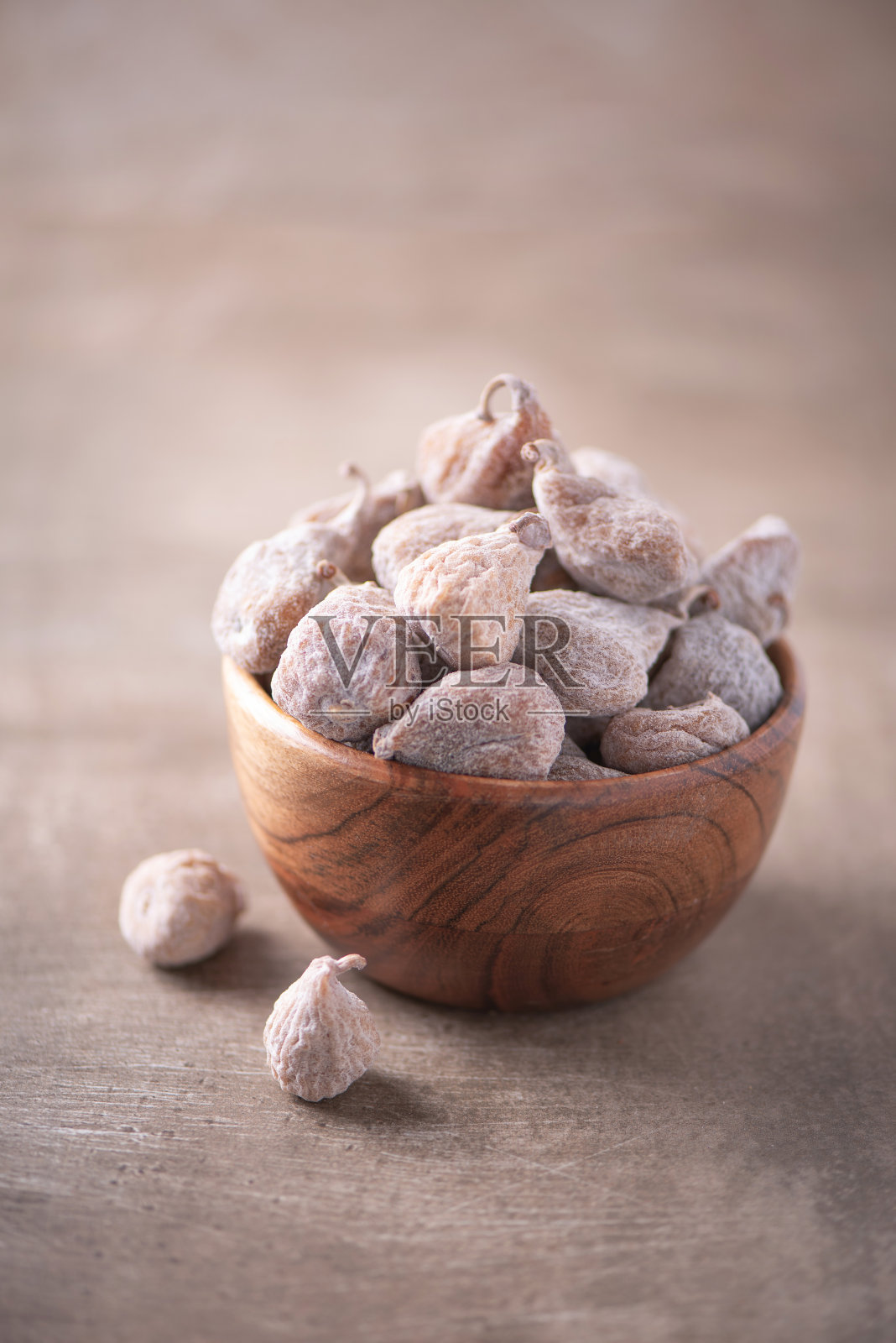 干无花果木碗木纹理背景。副本的空间。超级食物,素食,素食的概念。宏观的无花果纹理,选择焦点。健康的零食。照片摄影图片