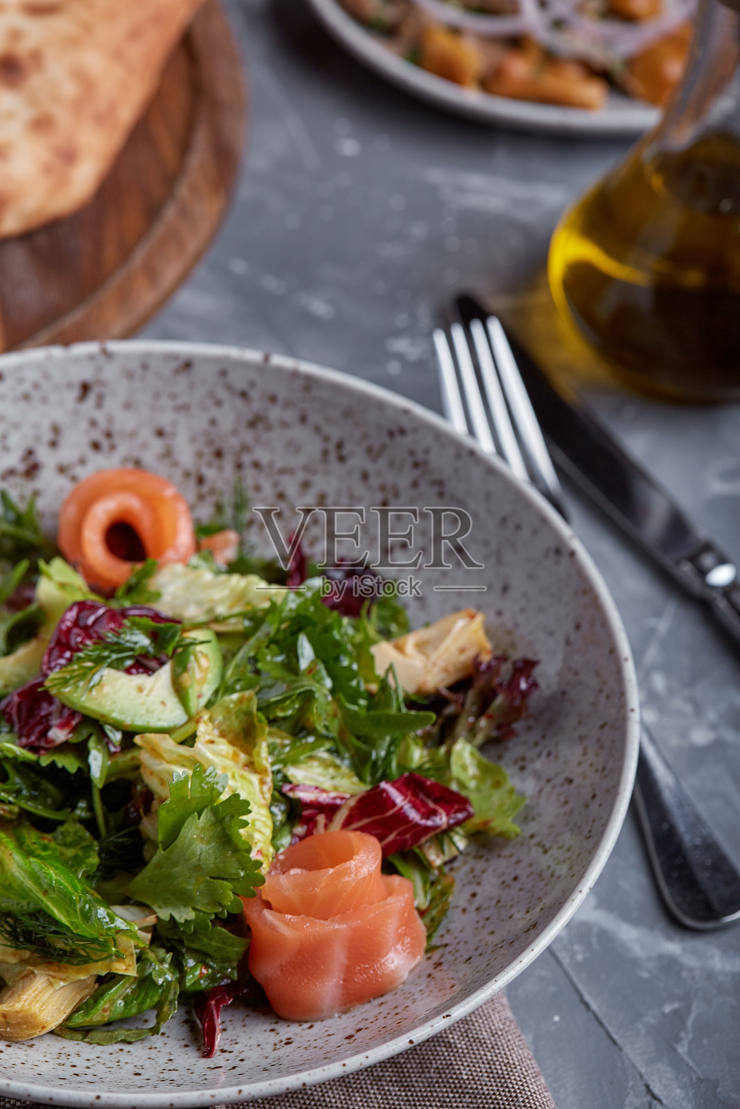 菠菜三文鱼沙拉,玉米沙拉,嫩菠菜,新鲜薄荷和罗勒。家里做的食物。一个美味和健康的概念。黑石的背景。前视图。近距离照片摄影图片