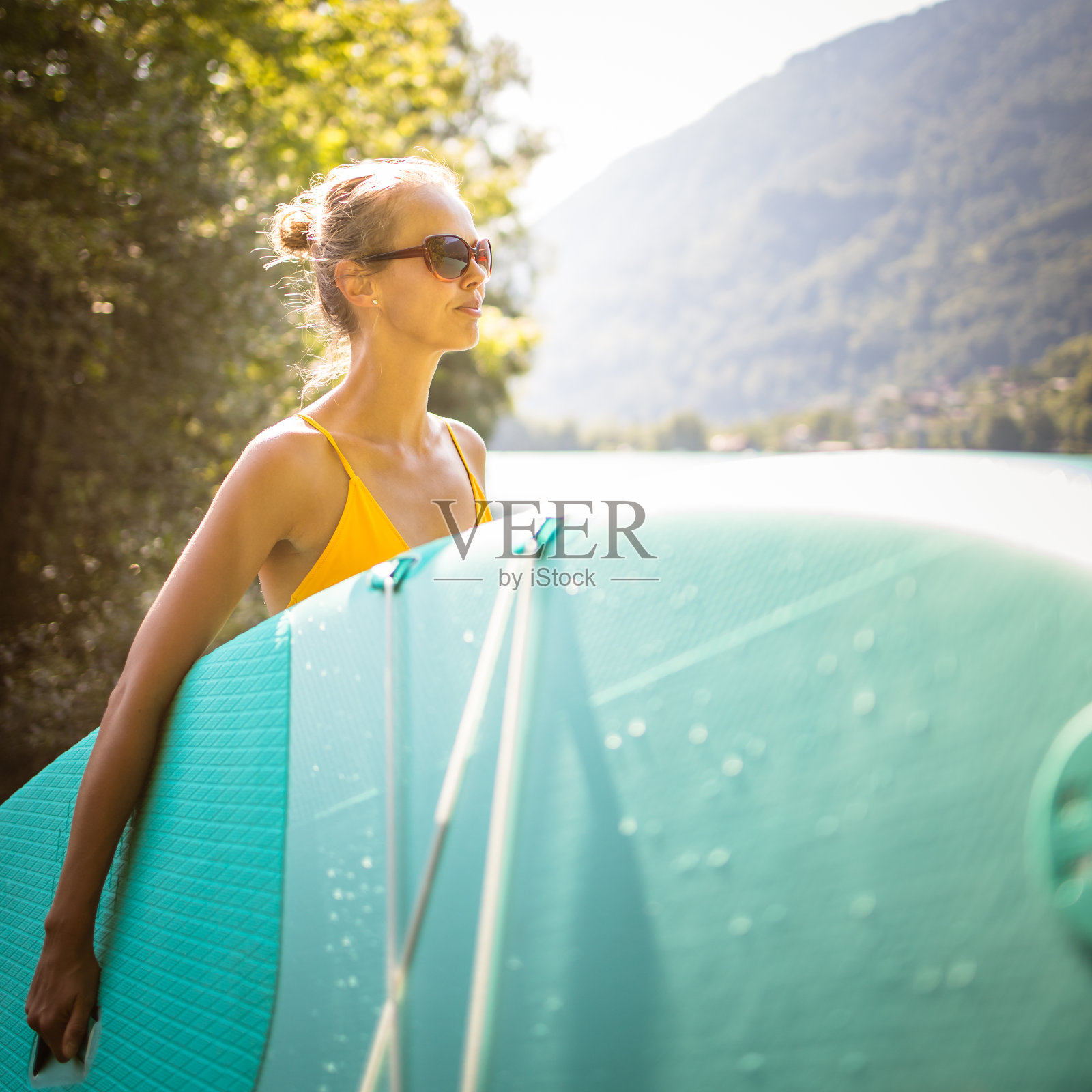 在湖上划桨板的年轻漂亮女子照片摄影图片