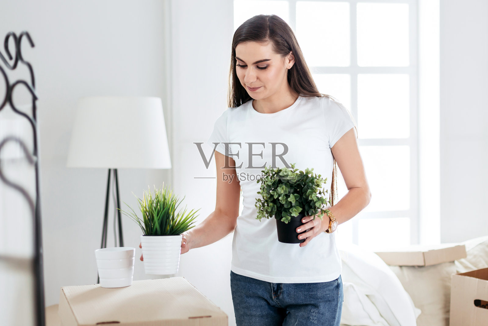 年轻女子在新公寓里放东西。照片摄影图片