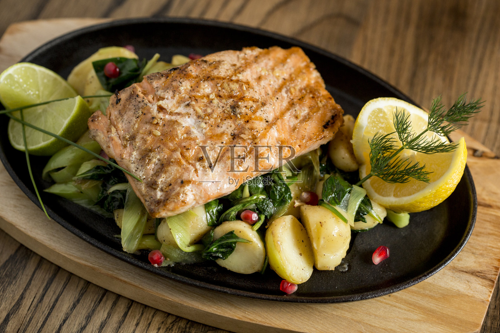 三文鱼片配烤土豆、韭菜及菠菜照片摄影图片