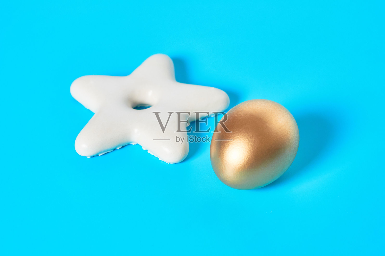 蓝色背景上的星星形状的金鸡蛋和饼干。复活节的概念照片摄影图片