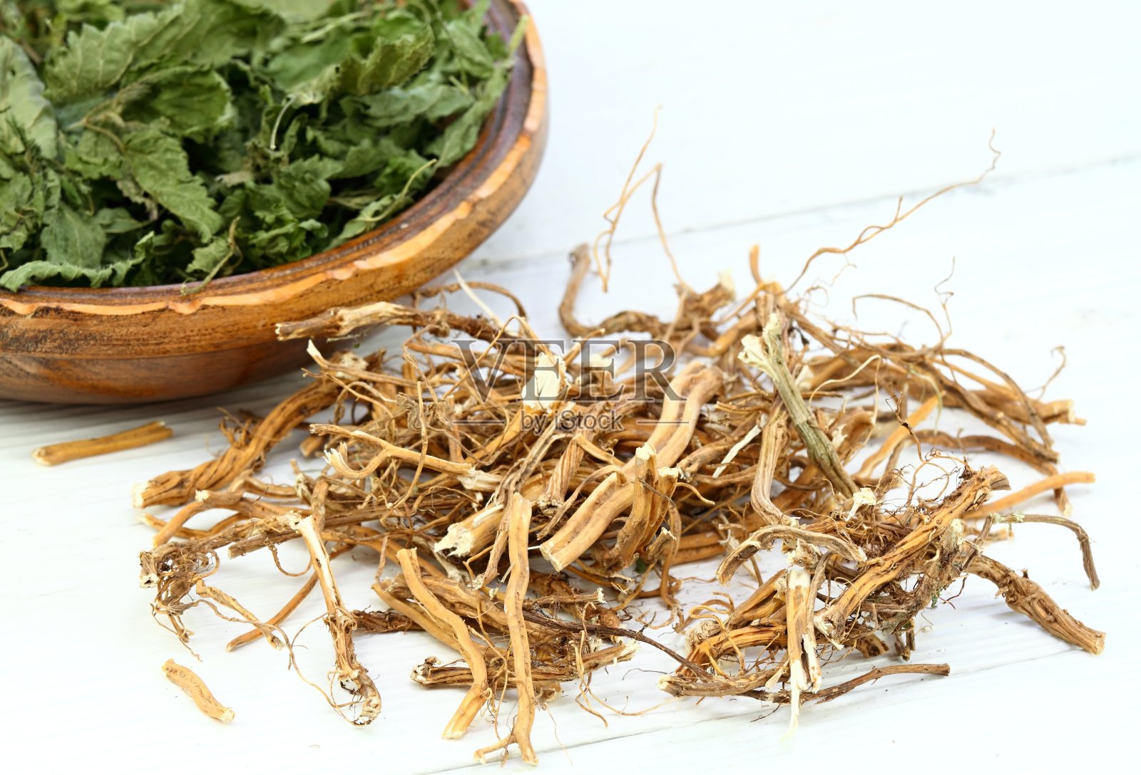 干荨麻的根和叶。白色桌子上的荨麻。照片摄影图片