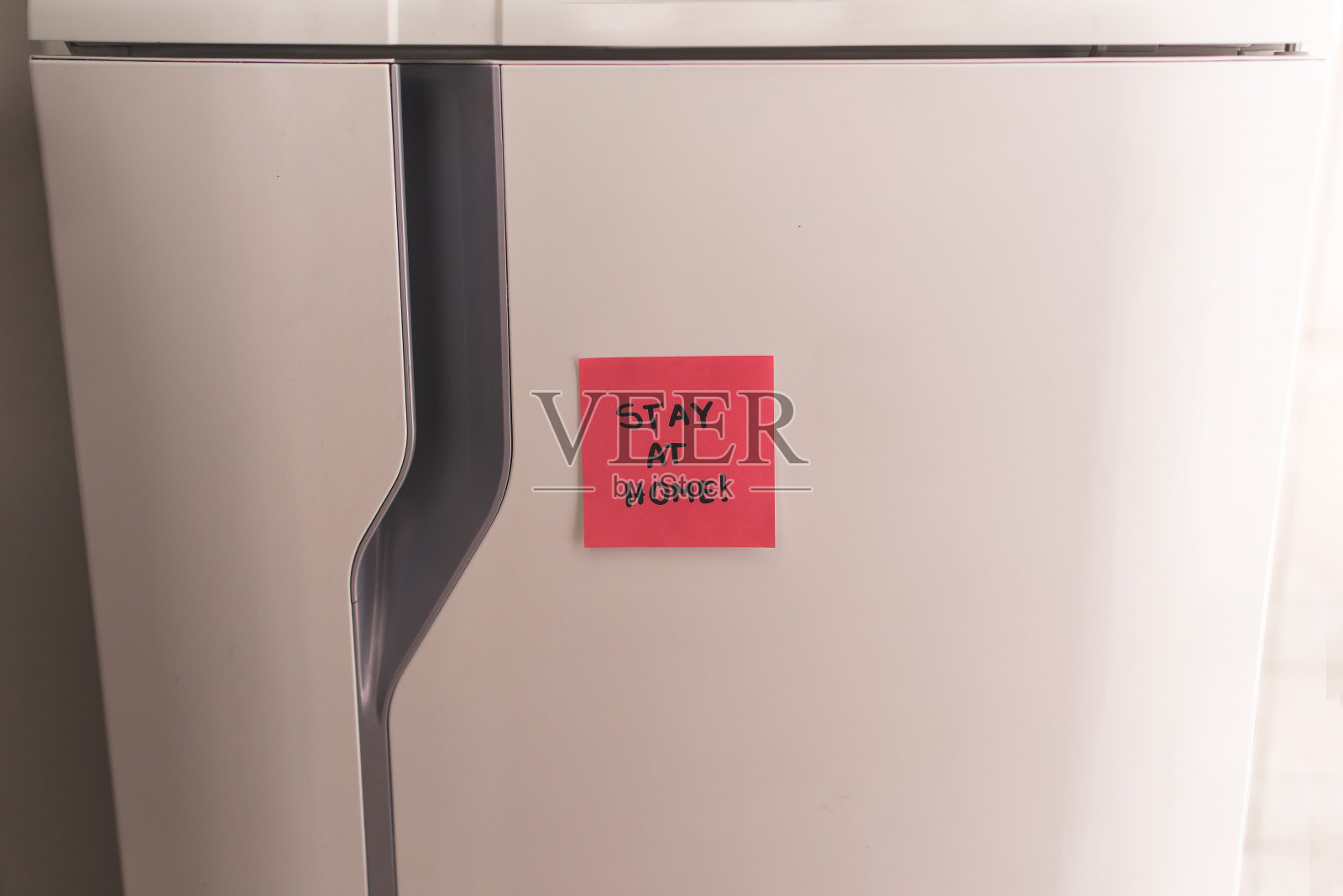 冰箱上贴着“待在家里”的便利贴!照片摄影图片