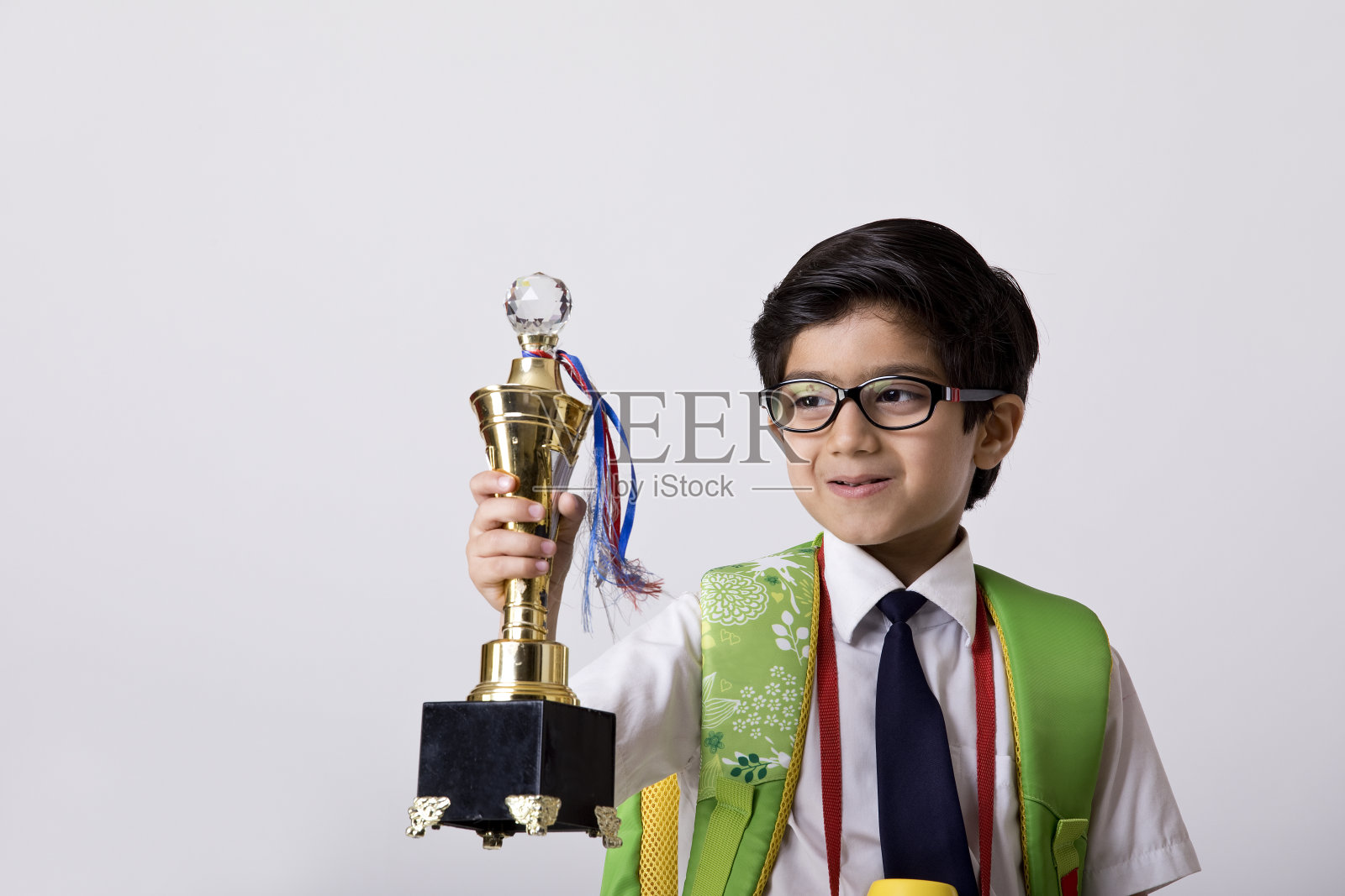 拿着奖杯庆祝成功的男生照片摄影图片