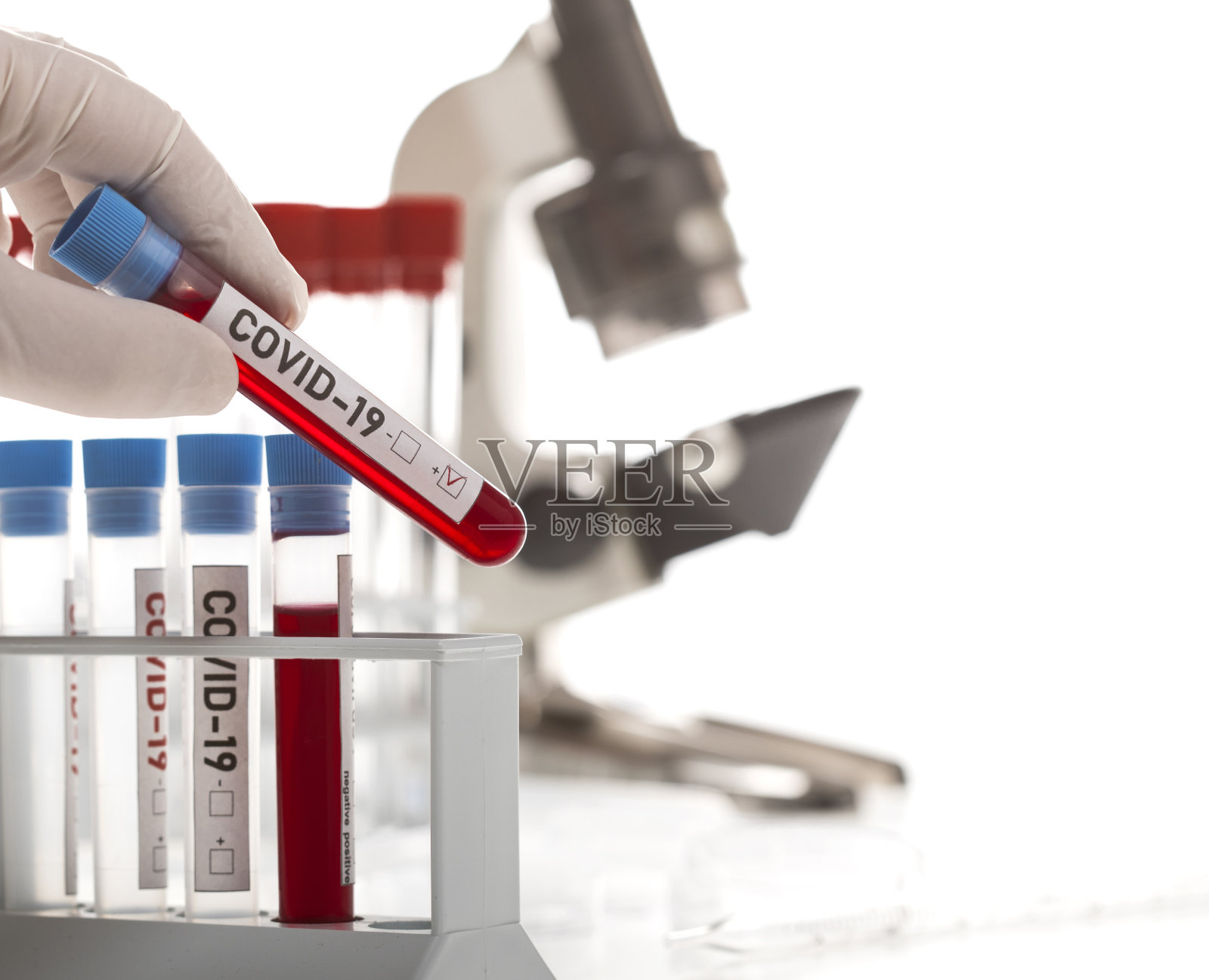 微生物学家,带一管标记为Covid-19的被冠状病毒污染的生物样本照片摄影图片