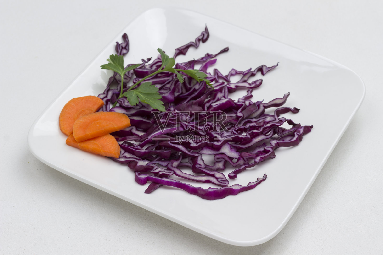 白盘子里的红卷心菜切片。健康的减肥食品照片摄影图片