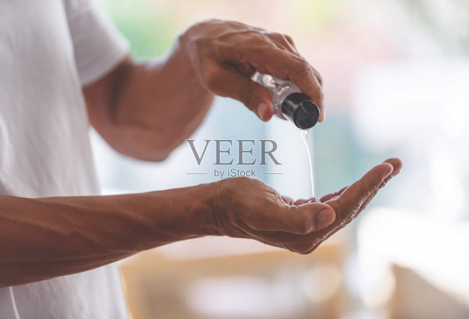 把洗手液抹在手上的男人。照片摄影图片