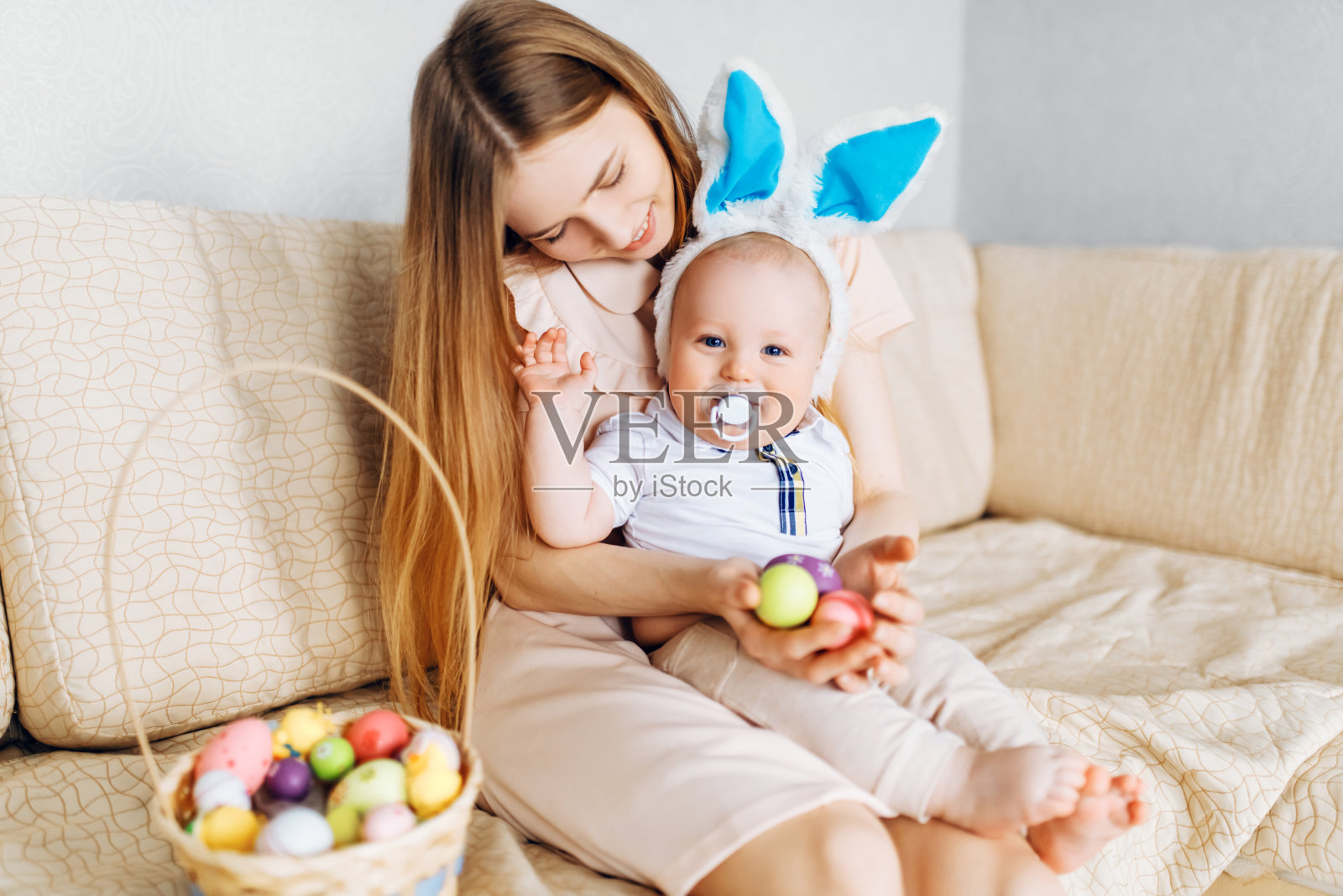 复活节快乐,戴着兔子耳朵的母婴玩耍复活节彩蛋照片摄影图片