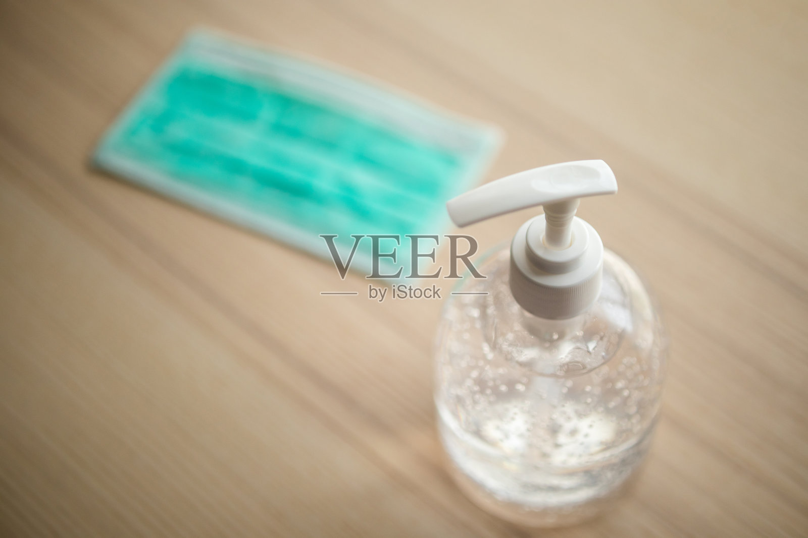 医用口罩与酒精消毒液凝胶洗手液放在木桌上,以预防covid-19冠状病毒照片摄影图片