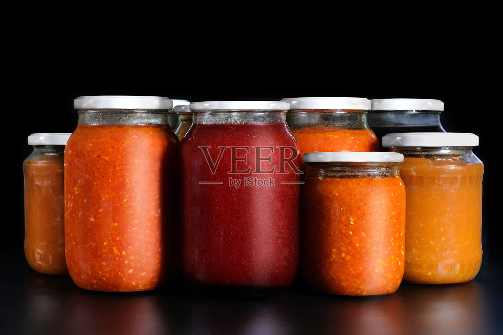 黑色背景上的泡菜。保存在玻璃罐中。蔬菜罐头的配料。照片摄影图片