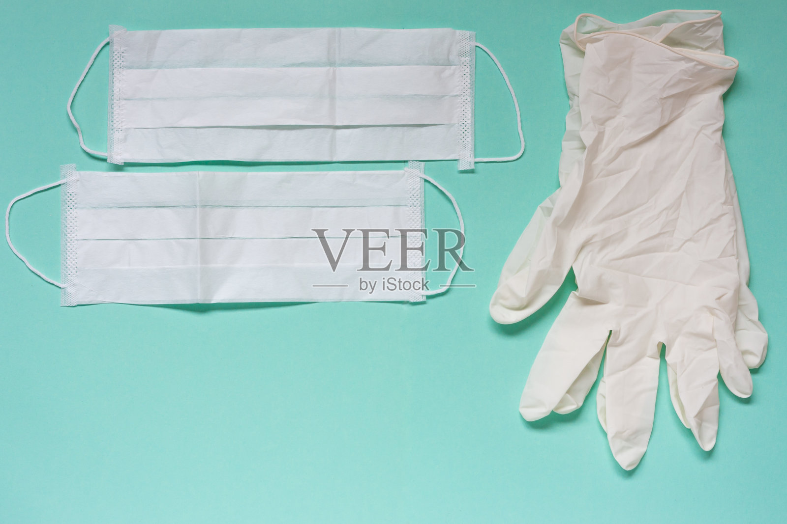 白色乳胶手套和医用面膜在海蓝宝石背景。预防大流行病,2019冠状病毒病照片摄影图片