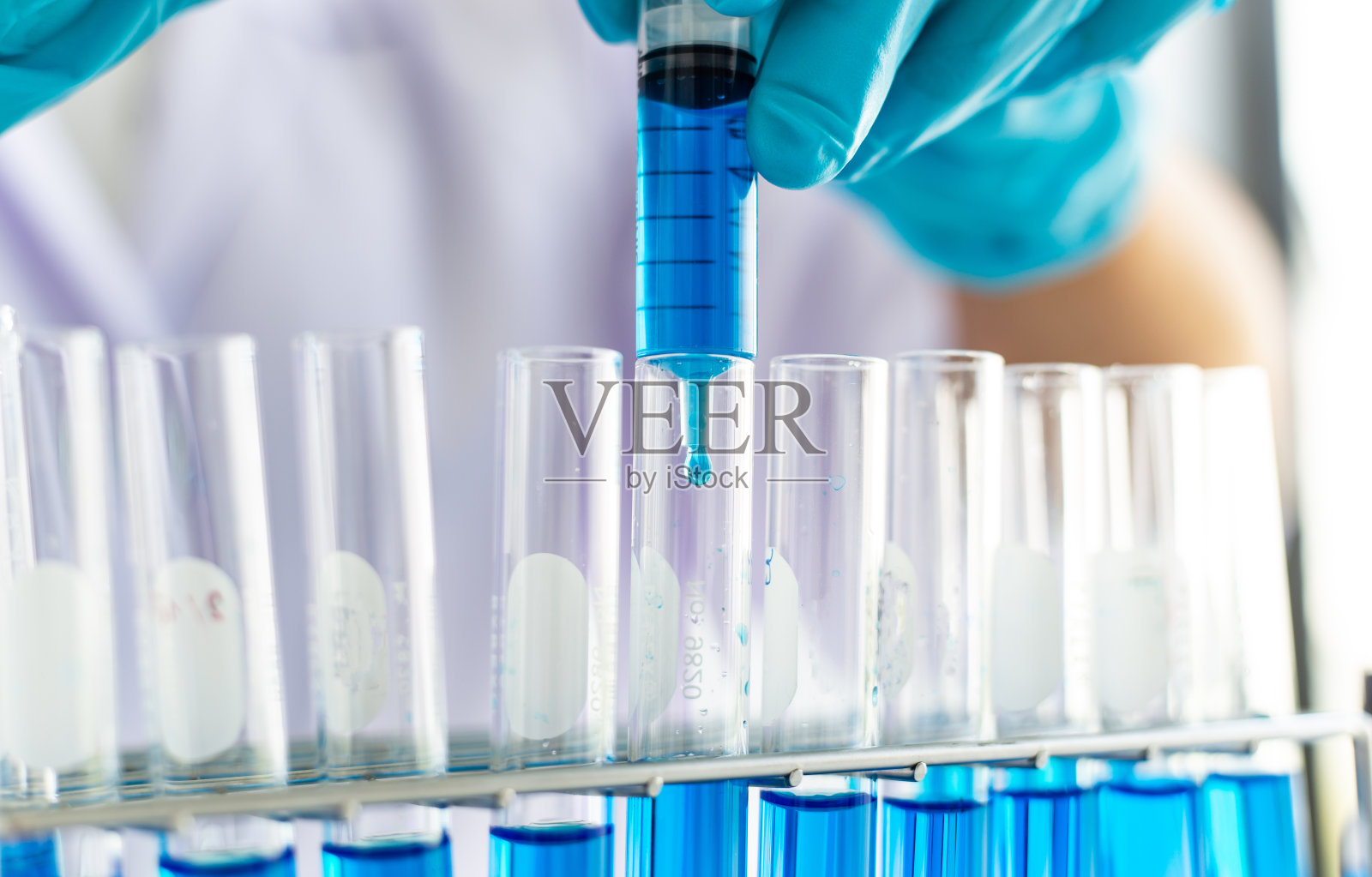 科学家们正携带着蓝色的化学试管,准备在一个科学实验室中测定化学成分和生物质量,科学家和研究在实验室的概念。照片摄影图片