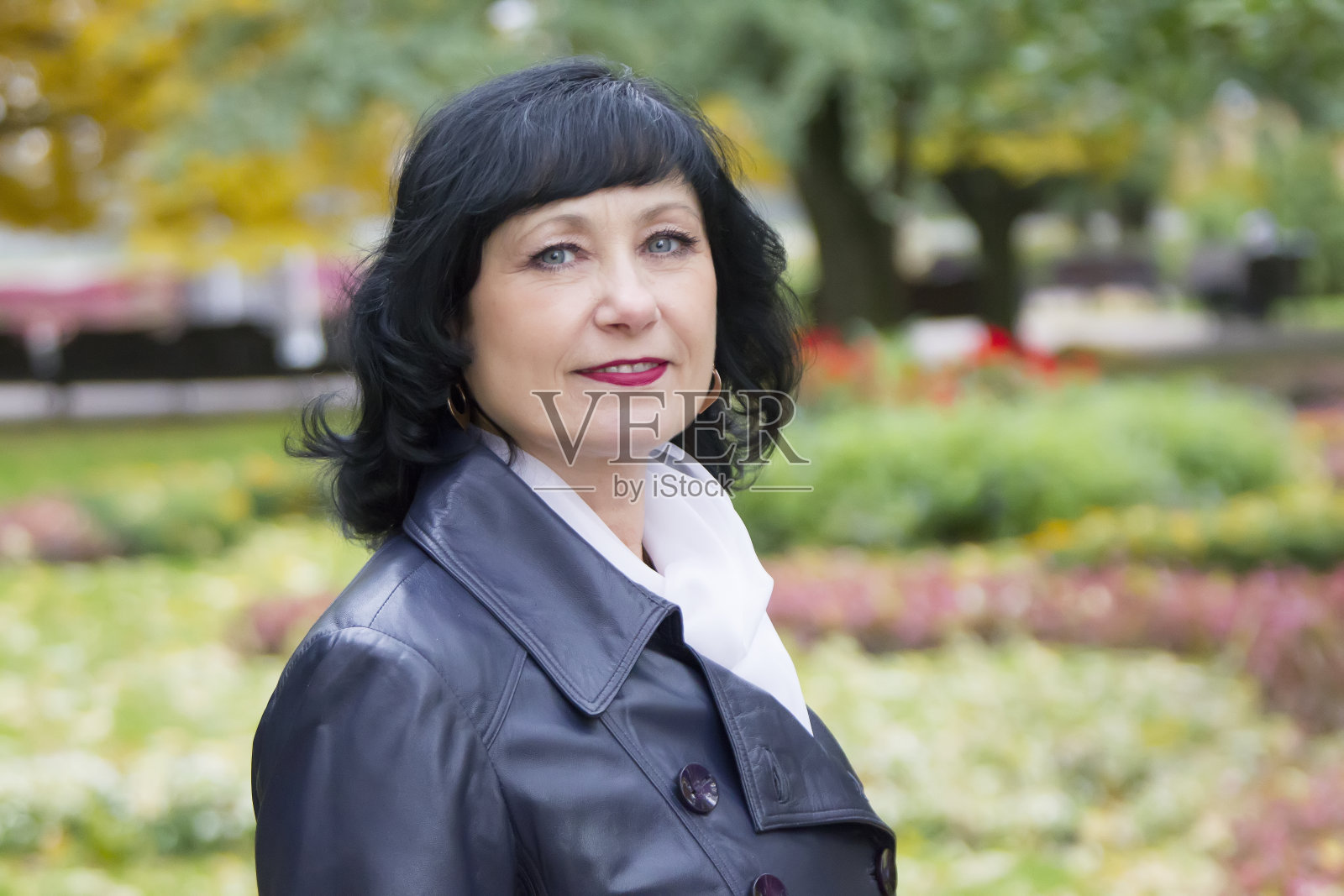 一个美丽的中年妇女的肖像。50岁的女人在公园里照片摄影图片
