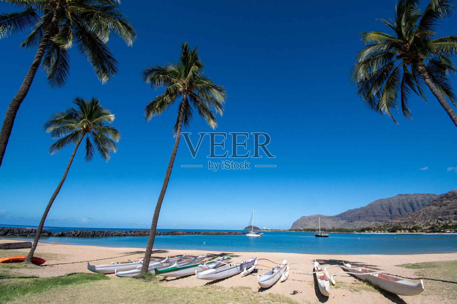 海滩上的支腿独木舟照片摄影图片