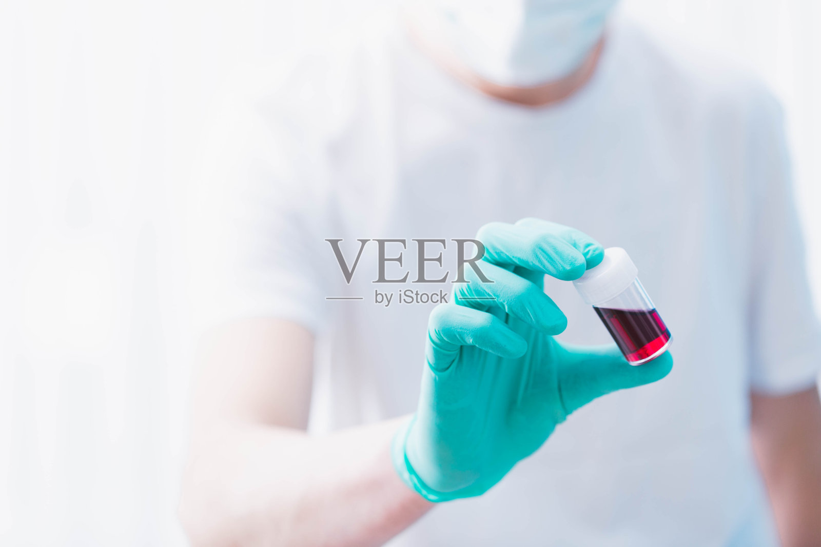 医生拿着冠状病毒阳性的血液试管。照片摄影图片