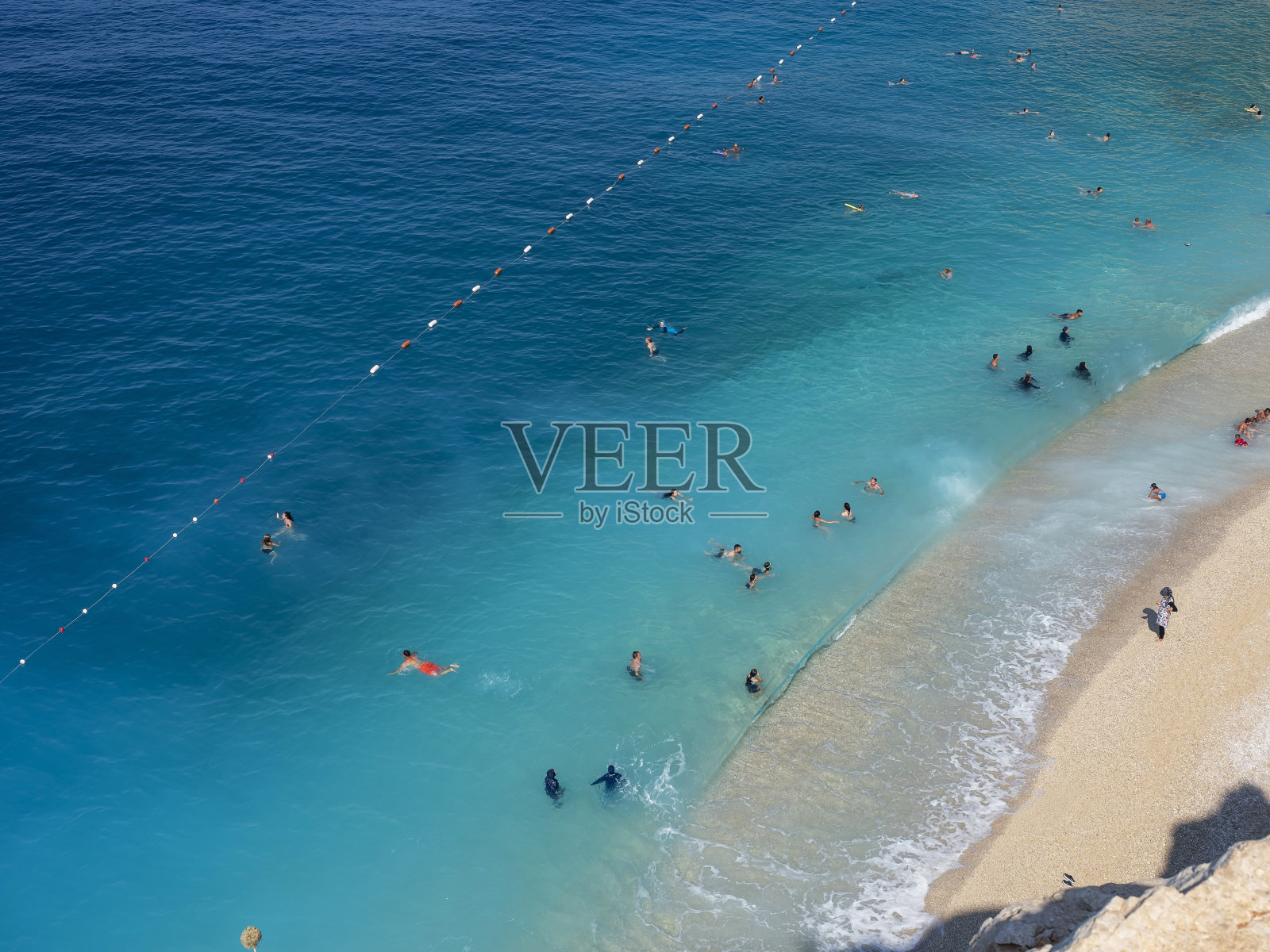 游客在土耳其安塔利亚卡普塔斯海滩晒太阳和游泳照片摄影图片