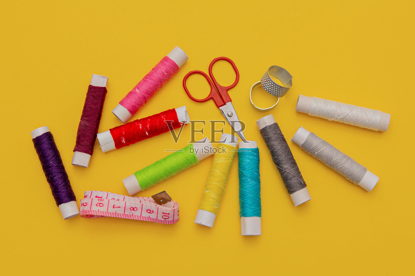 黄色背景上的线、针、剪刀和米。调整设置。针线包多彩照片摄影图片