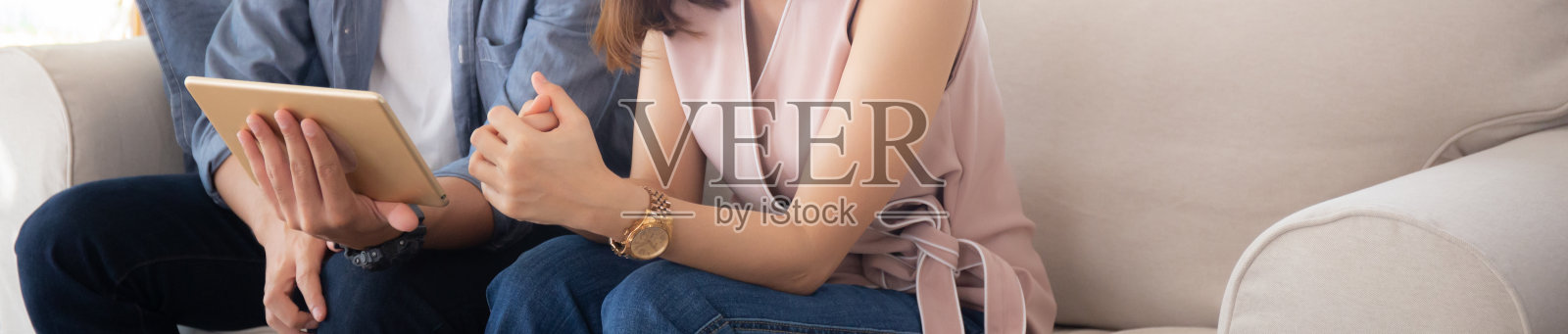 亚洲年轻夫妇在家里的沙发上一起放松看平板电脑上的娱乐,家庭休闲看电影与舒适的数字,生活方式和幸福的概念,横幅网站。照片摄影图片