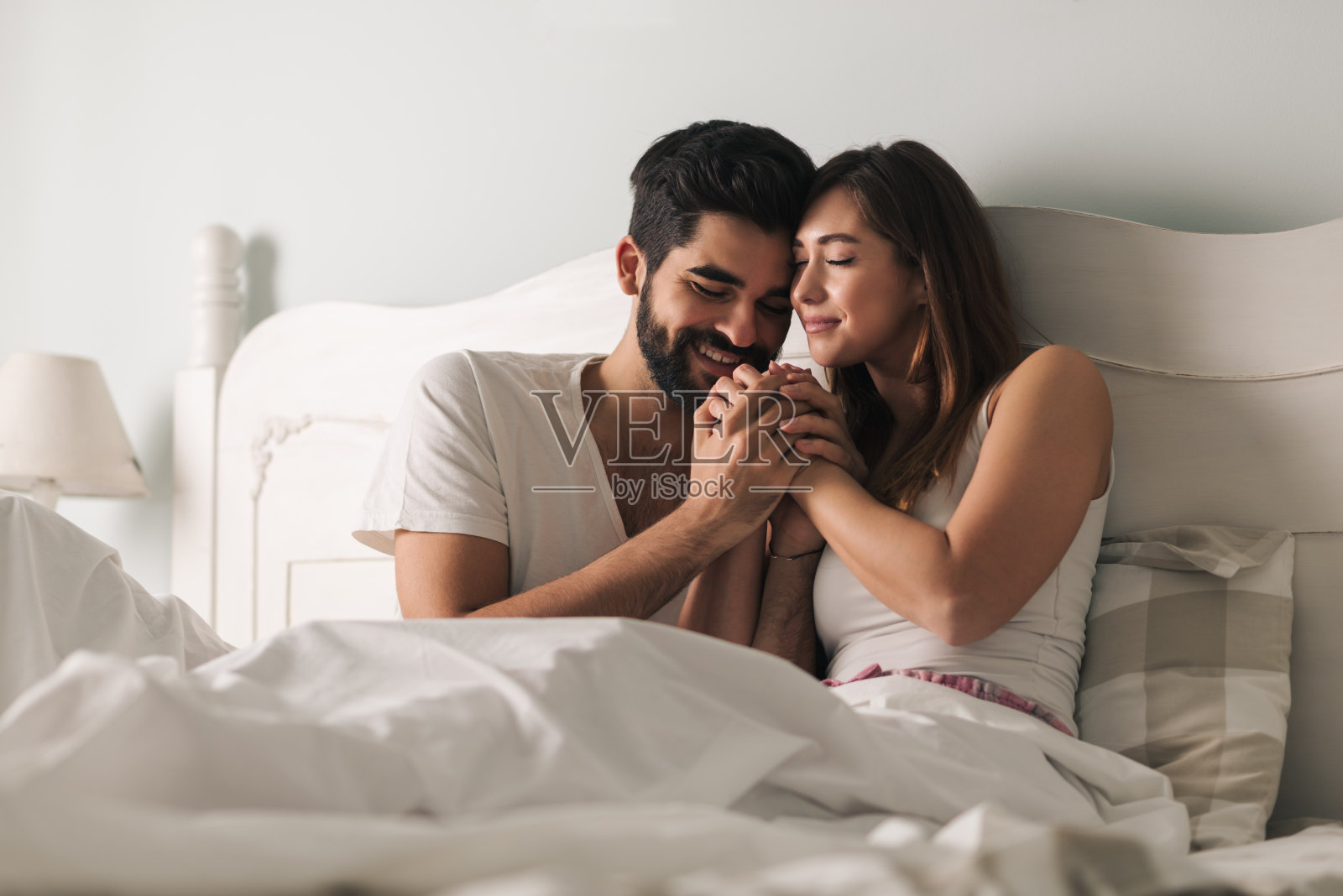 卧室里一对深情的年轻夫妇照片摄影图片