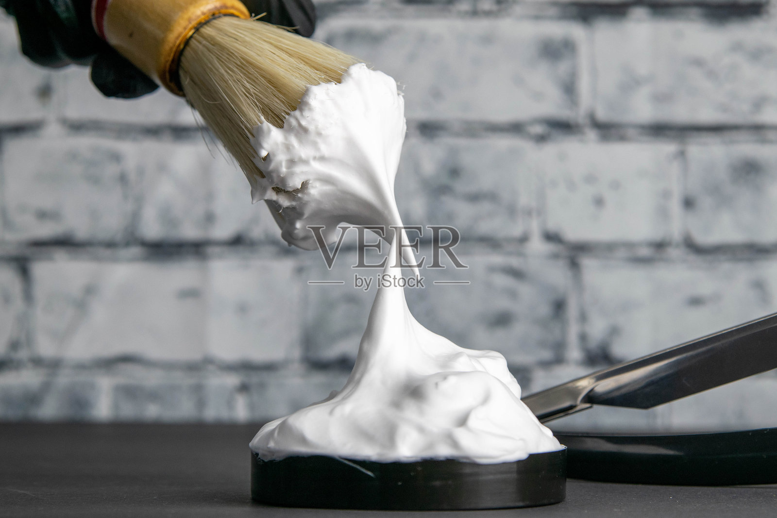 手持刷子用于应用泡沫的胡子,泡沫和危险的剃刀在黑色背景。美容的概念照片摄影图片