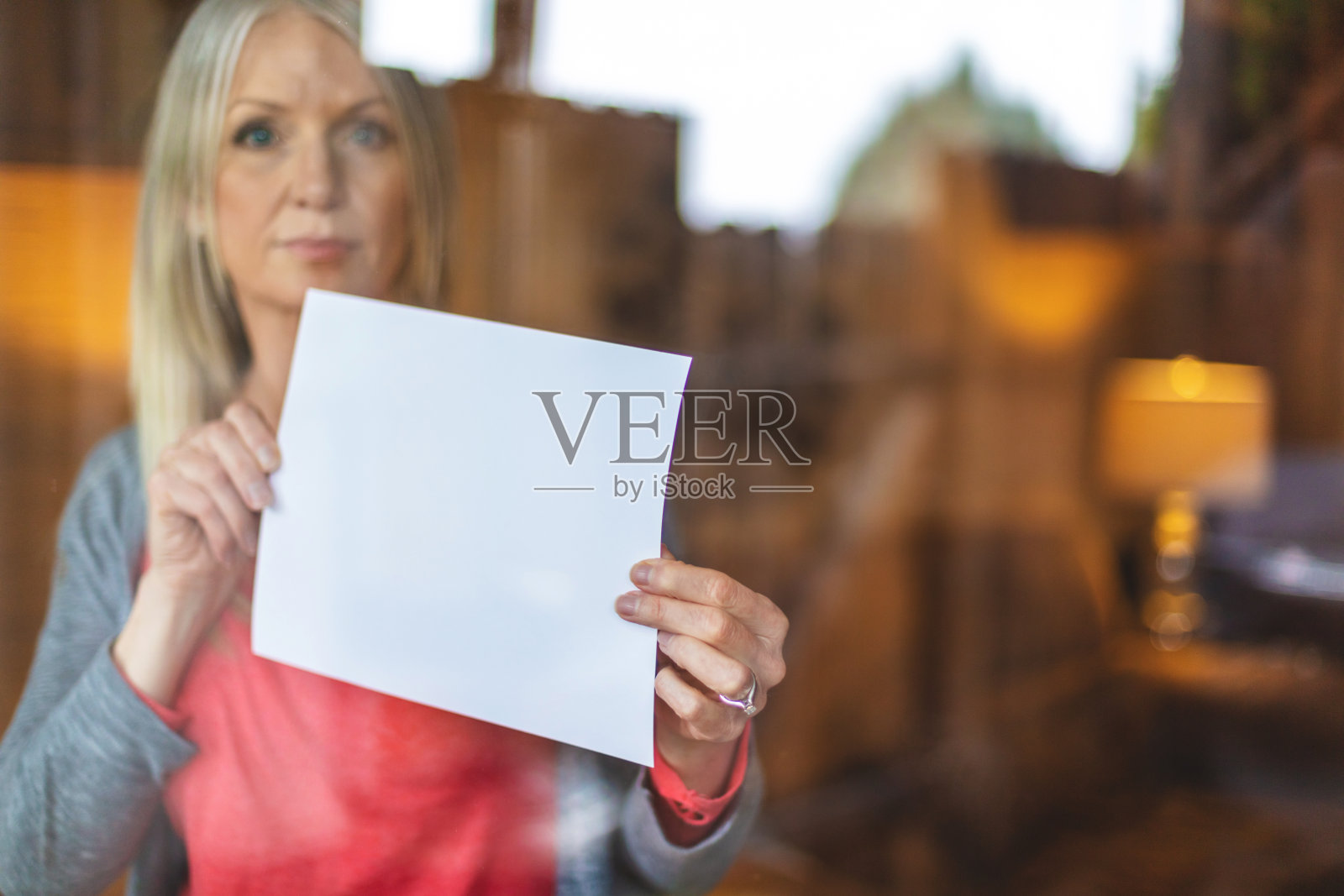 疫情期间中年妇女居家隔离,手持标语照片摄影图片