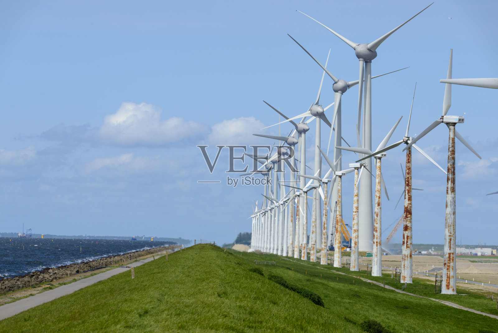 陈旧生锈的风力涡轮机被更大更高效的新风力涡轮机所取代照片摄影图片