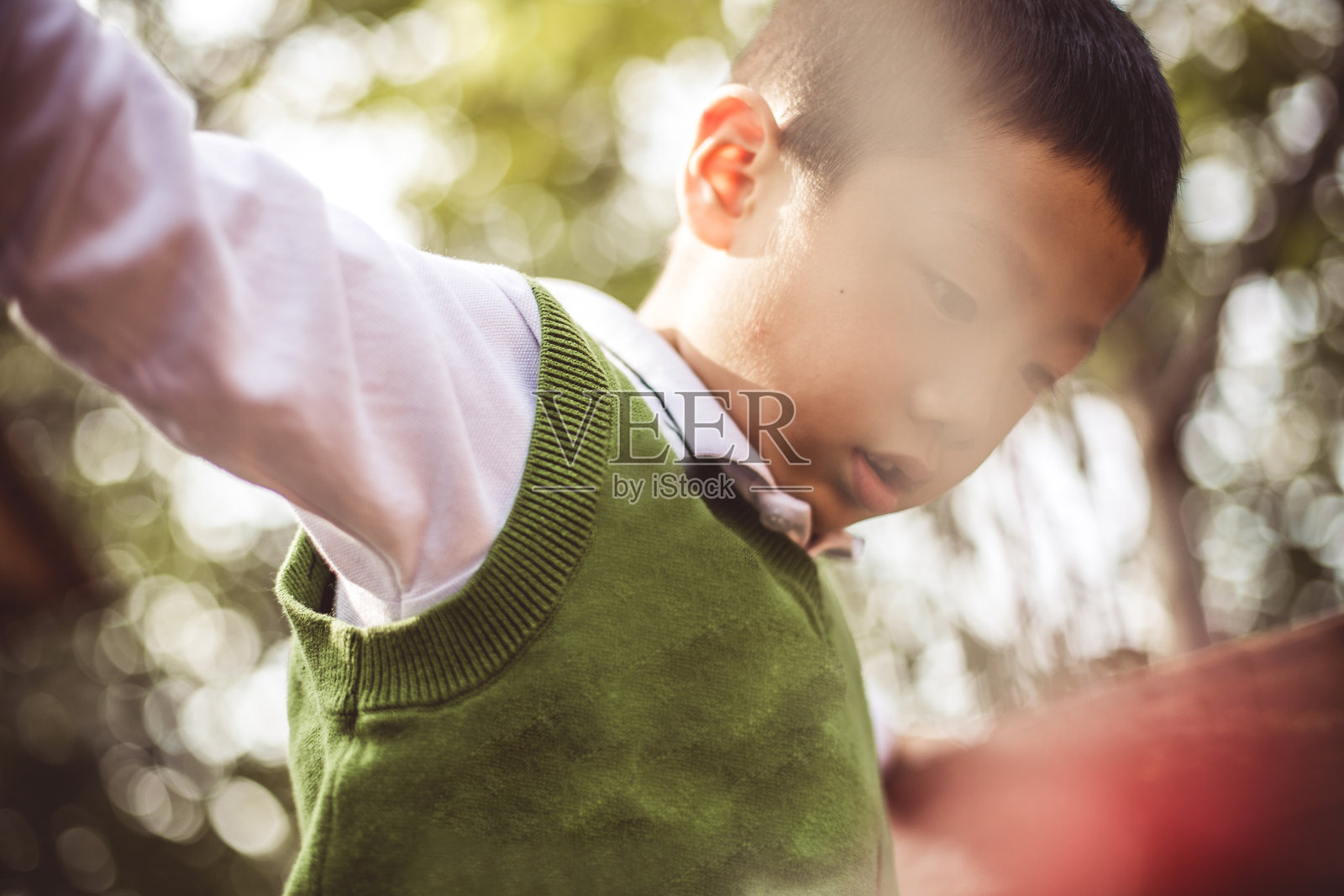 一个亚洲小男孩在操场上爬照片摄影图片