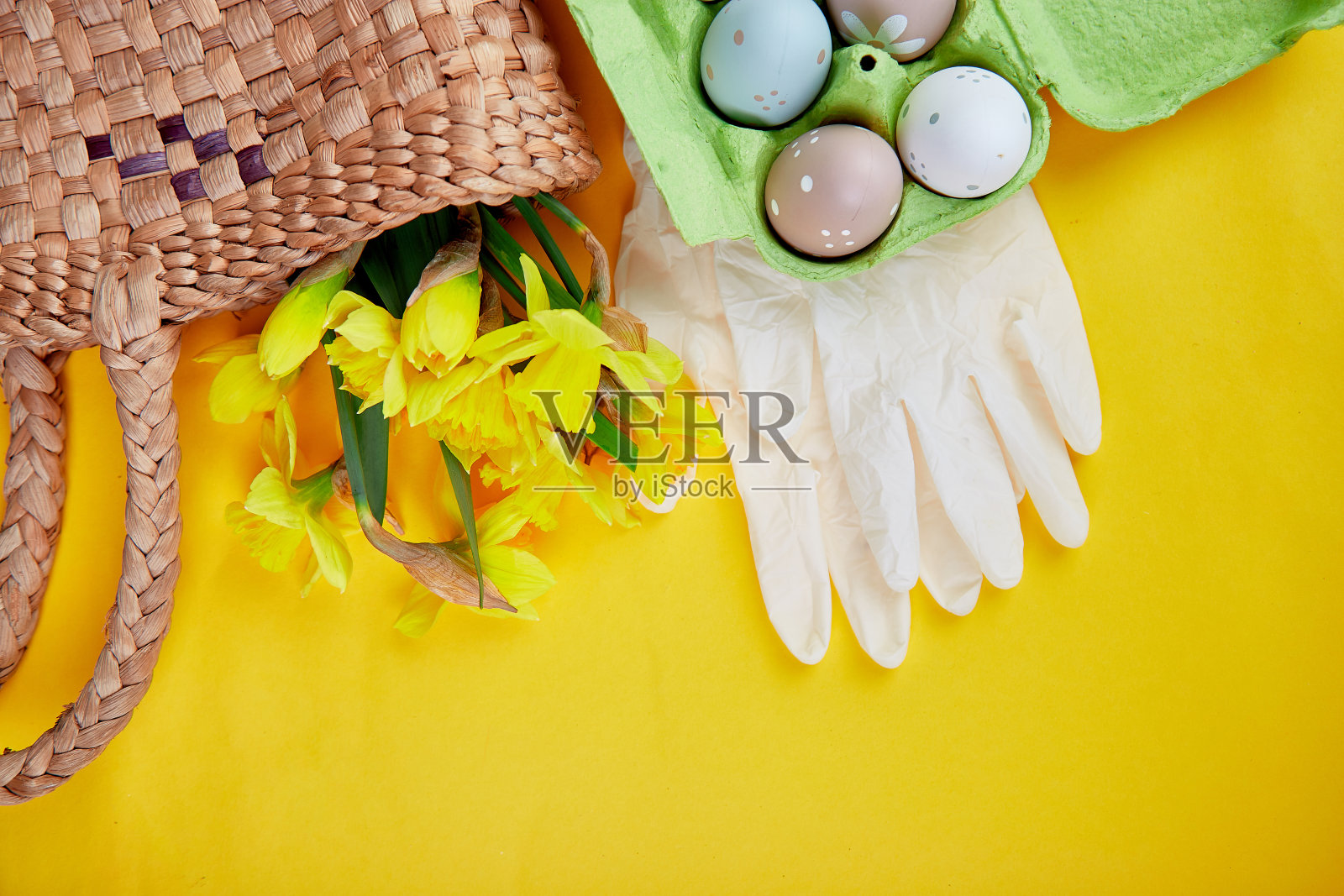冠状病毒复活节标志鸡蛋和水仙花放在篮子里,靠近防护医疗手套照片摄影图片