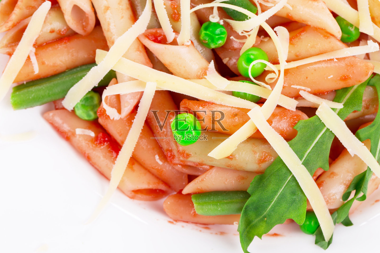 一小片通心粉,配番茄酱和蔬菜。照片摄影图片