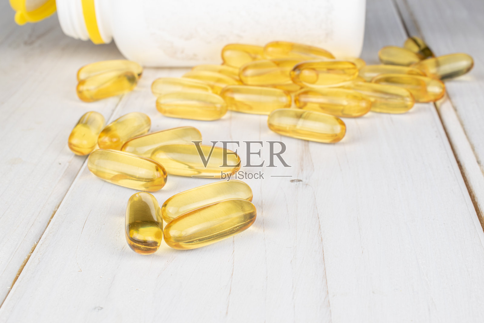 灰色木材上的金色鱼油照片摄影图片