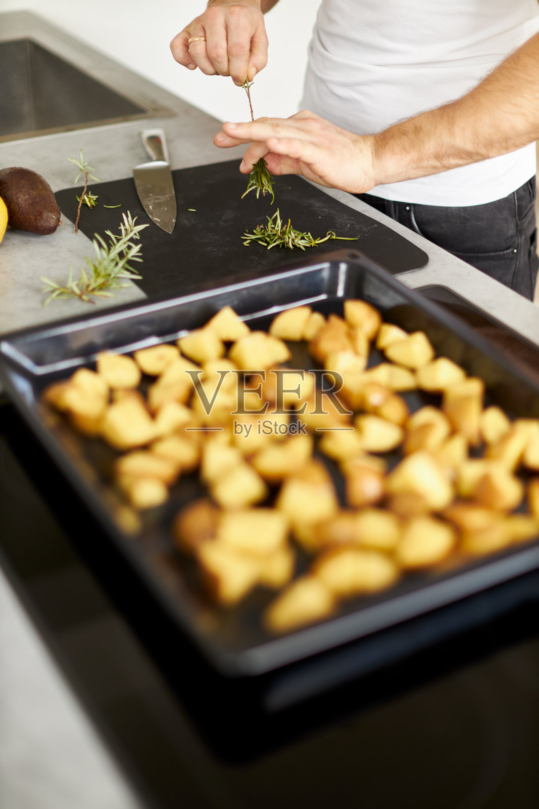 各种各样的照片,一个年轻人穿着白色t恤在一个伟大的设计厨房烹饪健康的食物照片摄影图片