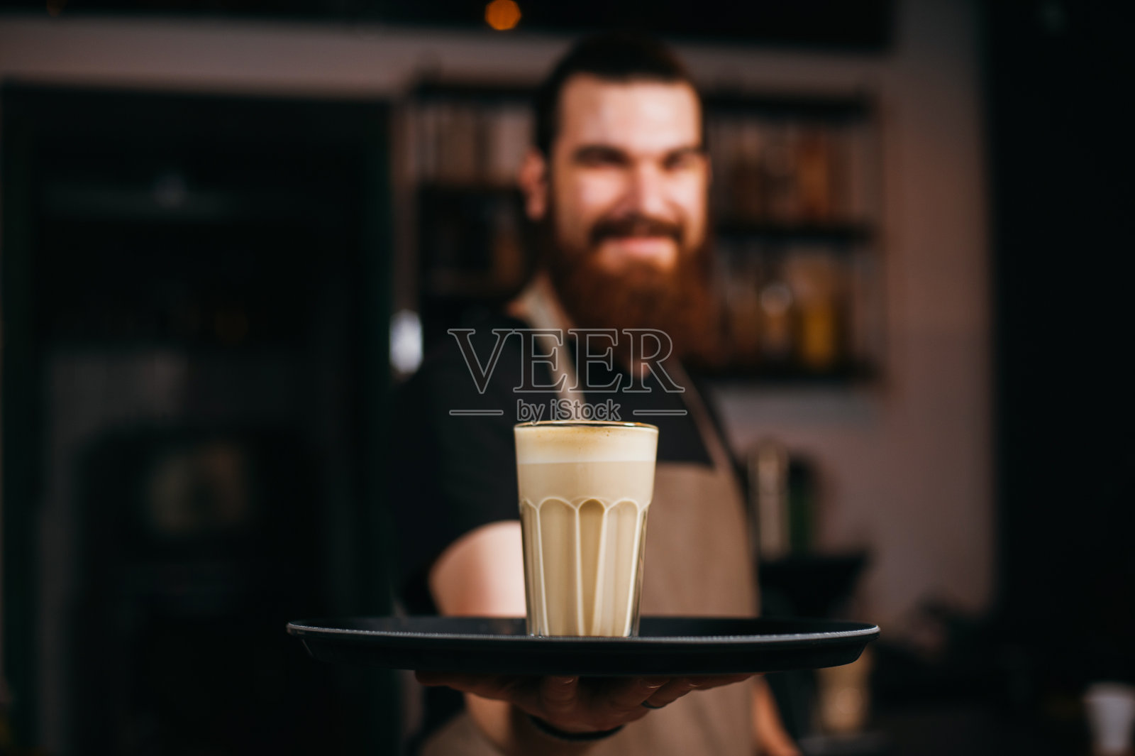 笑容满面的咖啡师在咖啡店手持外卖杯照片摄影图片