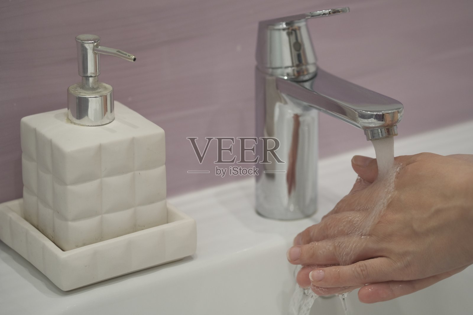 用肥皂在起重机下用水洗手照片摄影图片