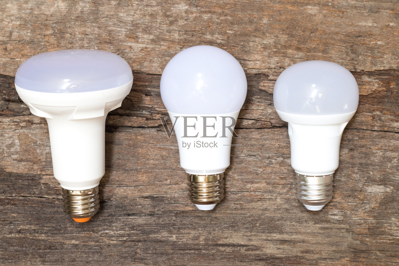 节能的概念。亚洲人更换紧凑型荧光灯(CFL)灯泡与新的LED灯泡。照片摄影图片