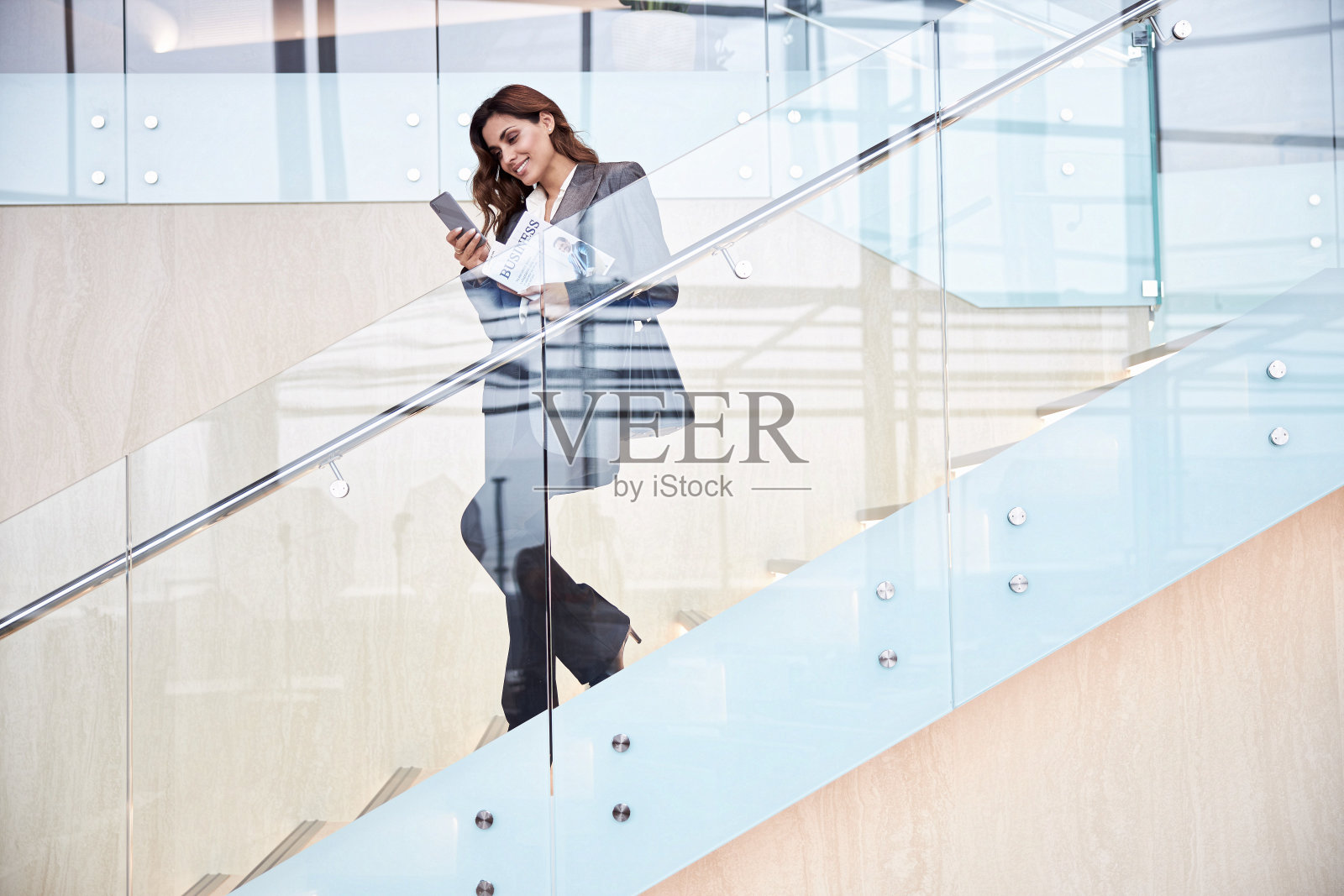 站在楼梯上并使用手机的迷人女子照片摄影图片