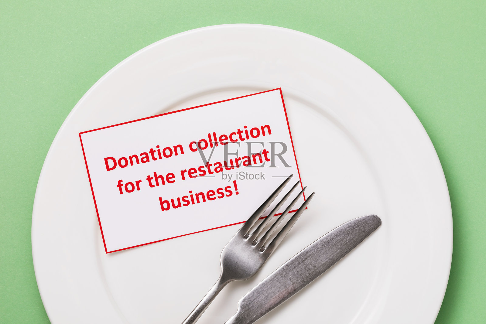 标签与文字和盘子与餐具在桌子上,俯视图。关于因新冠肺炎大流行向咖啡馆和餐馆捐赠资金主题的概念照片摄影图片