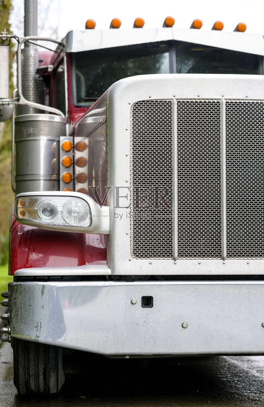经典湿大卡车红色半卡车与铬格栅和保险杠站在街道在下雨的天气照片摄影图片