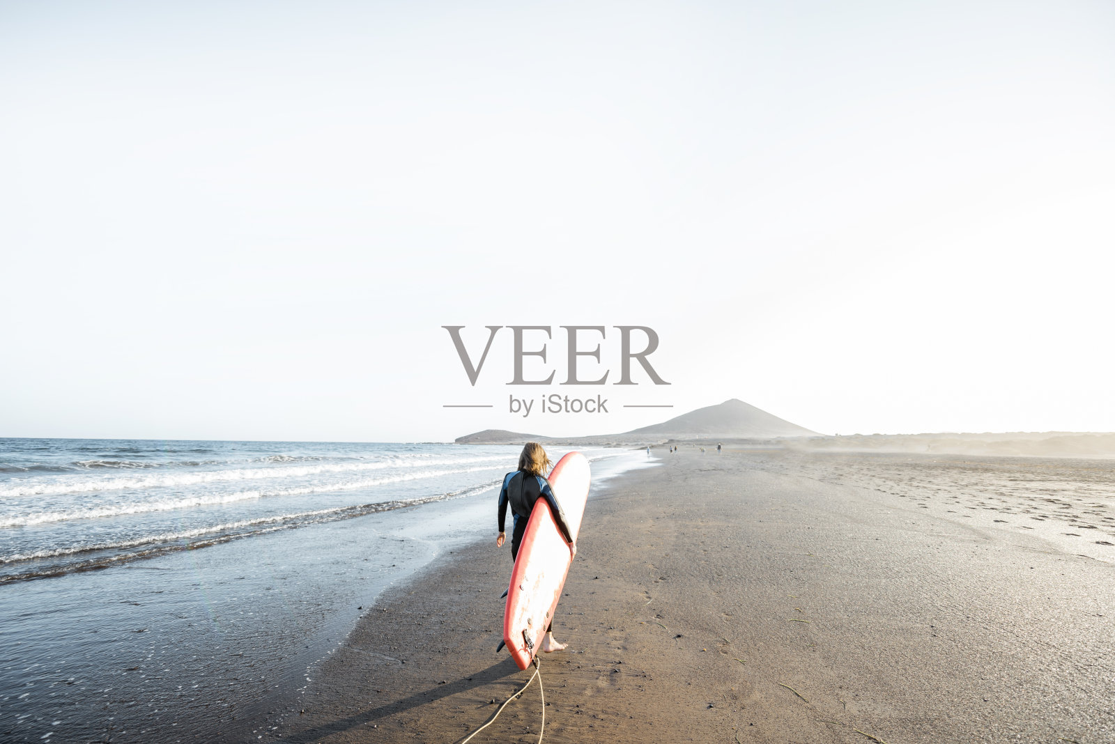 年轻的冲浪者和冲浪板在海滩上照片摄影图片