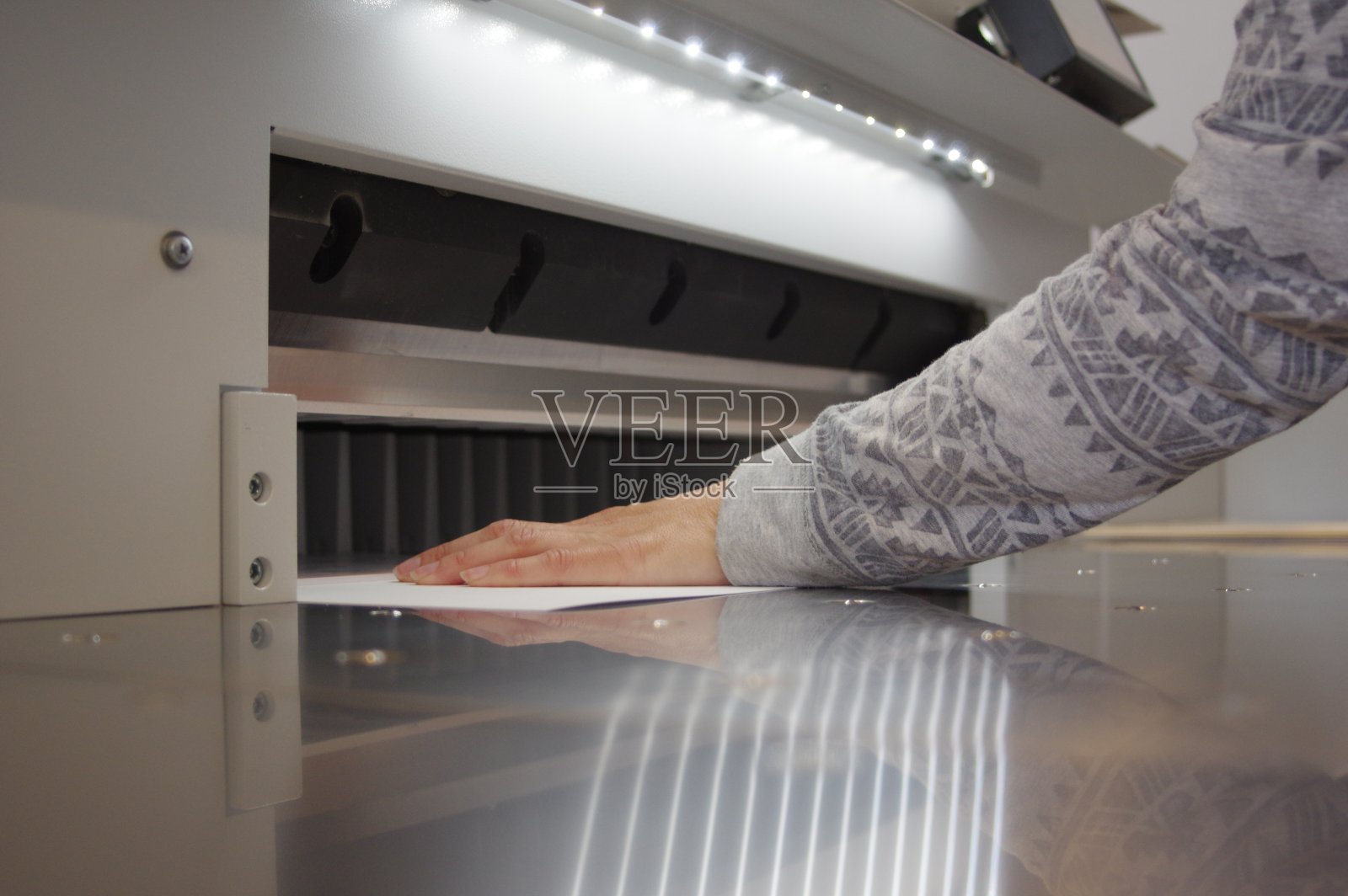 在断头台上裁纸。印刷的房子。切纸刀。照片摄影图片