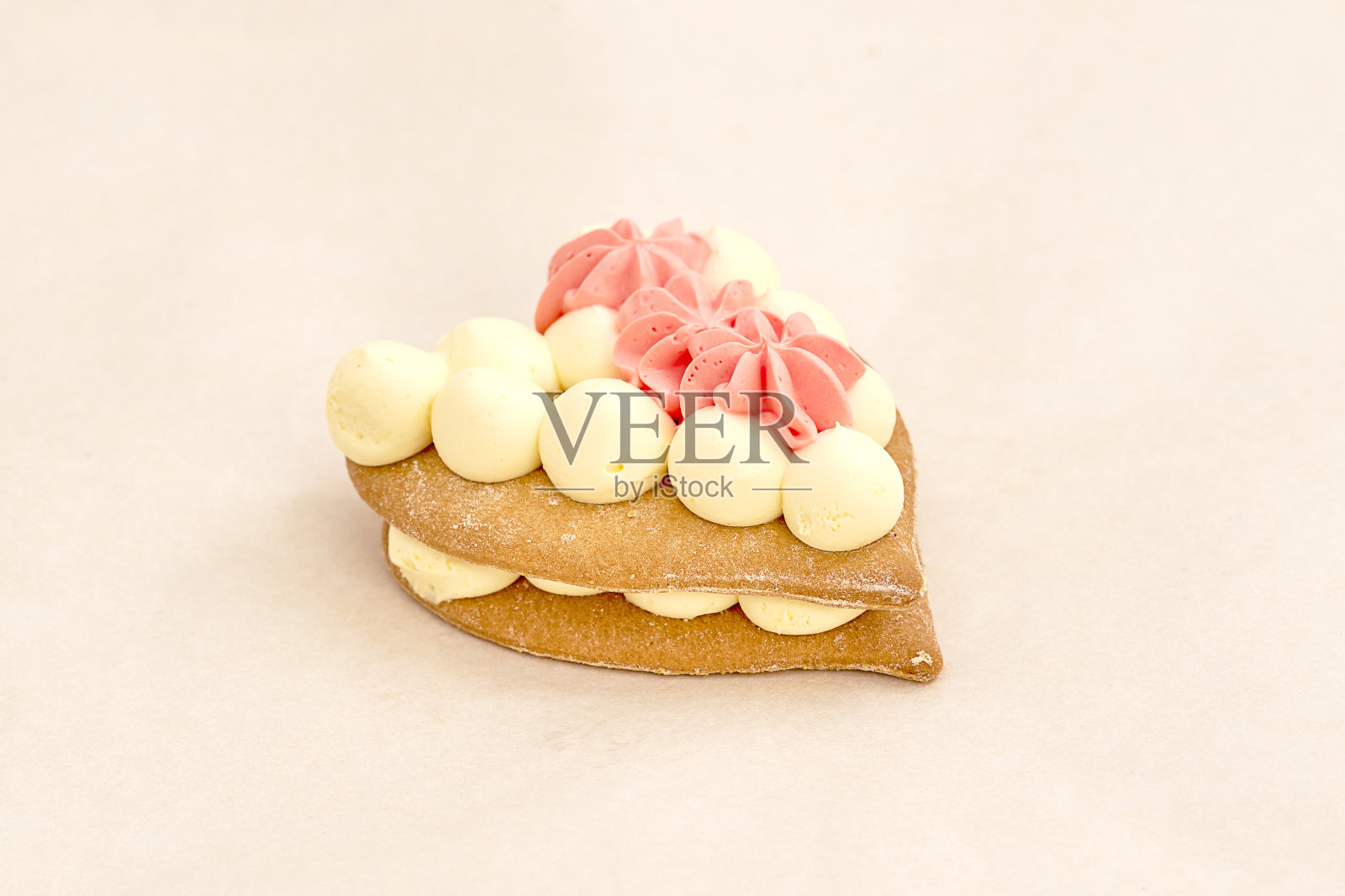 心形蛋糕,上面有奶油白色的球和粉红色的奶油。新鲜糕点,各种面包店和面包房。灯光背景的特写照片摄影图片