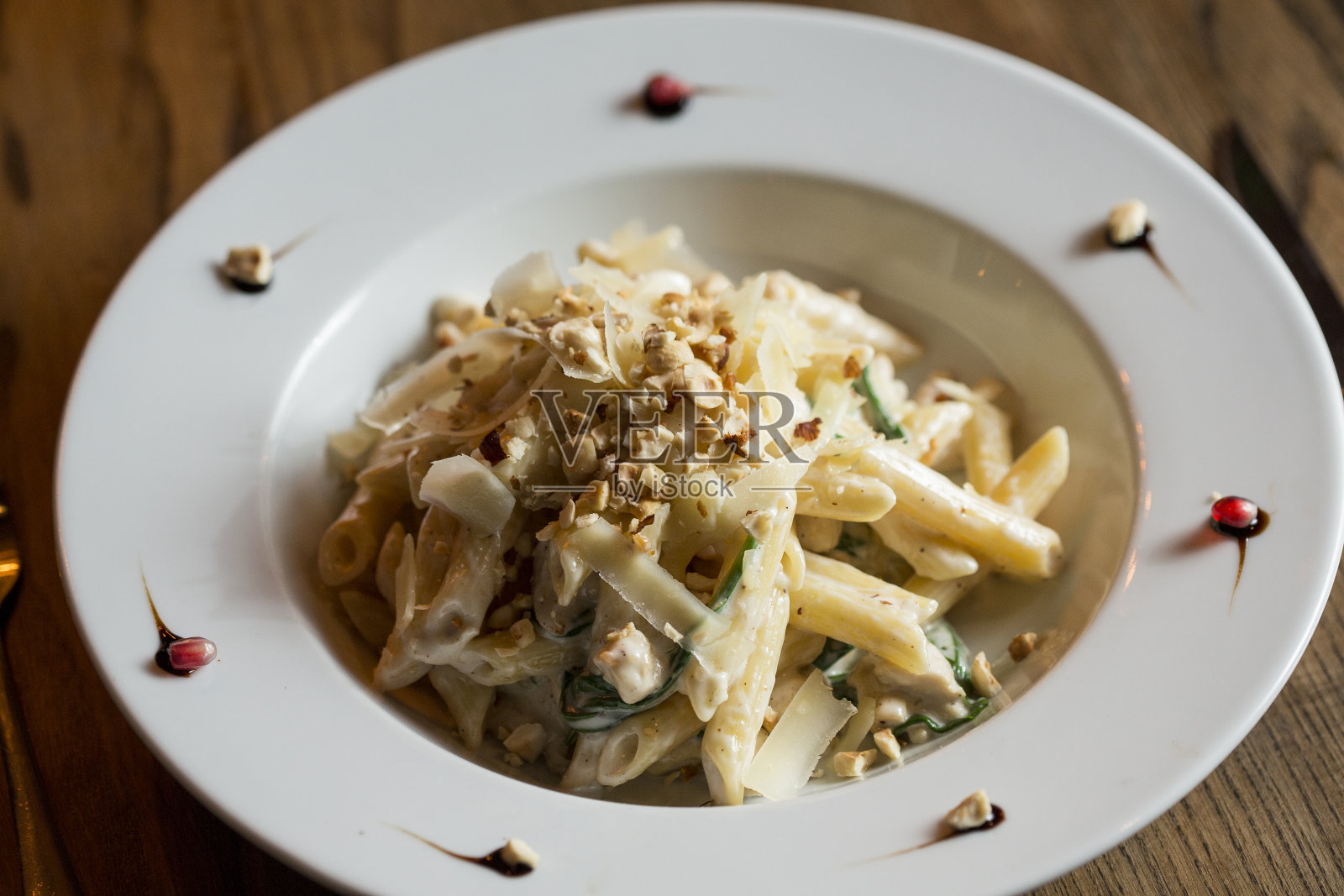 配鸡肉、菠菜和帕玛森酱榛子的通心粉照片摄影图片