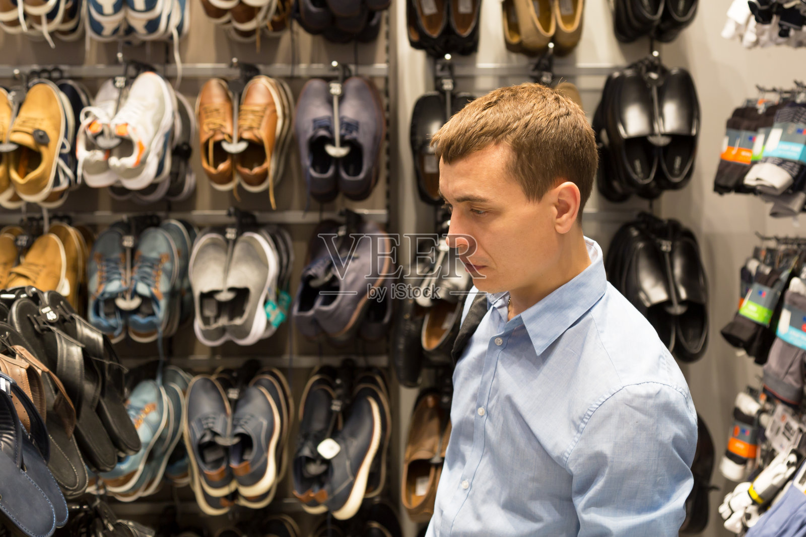 男人在商店里挑选鞋子照片摄影图片