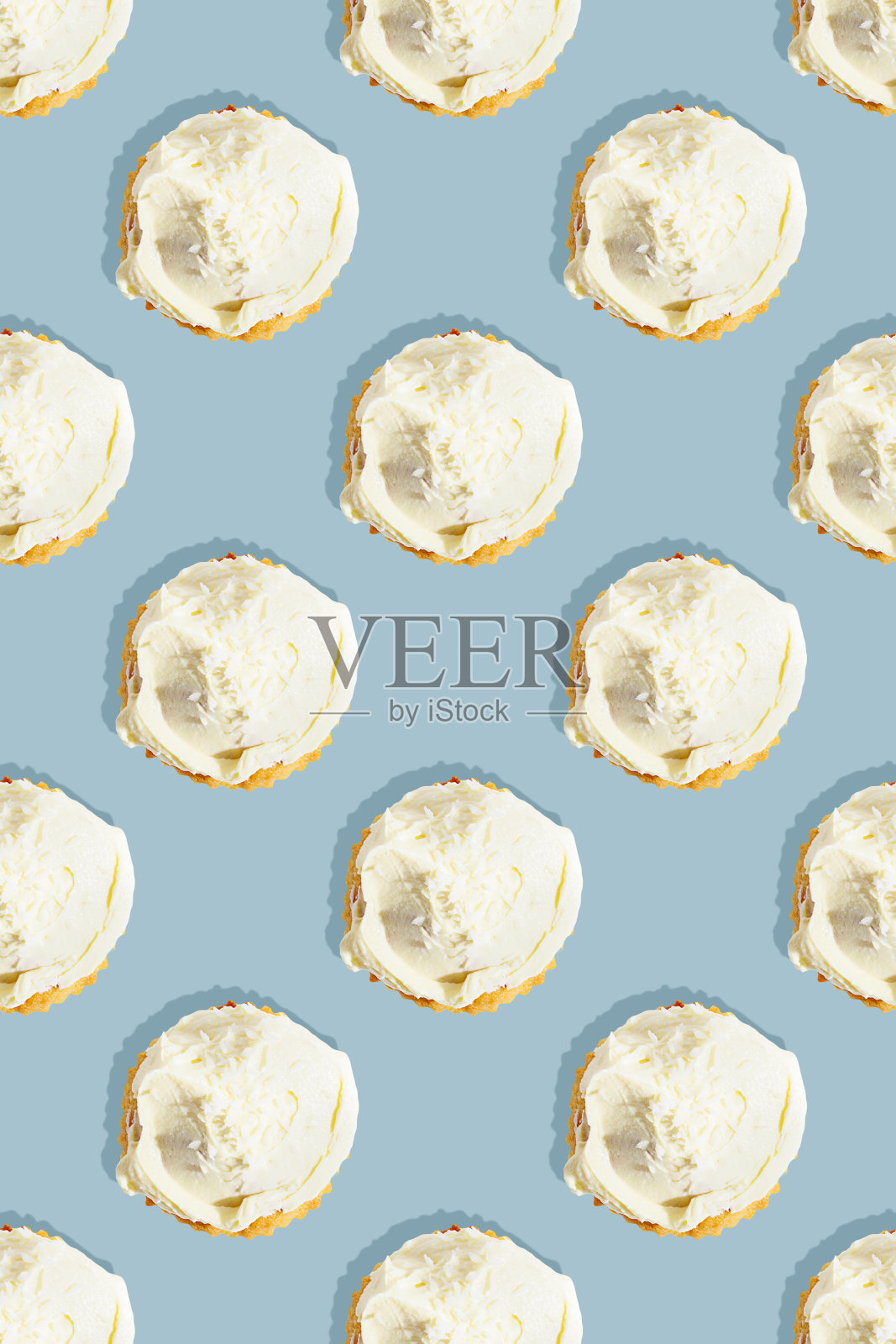 无缝图案的椰子纸杯蛋糕与白色发泡香草冰淇淋在蓝色的背景照片摄影图片