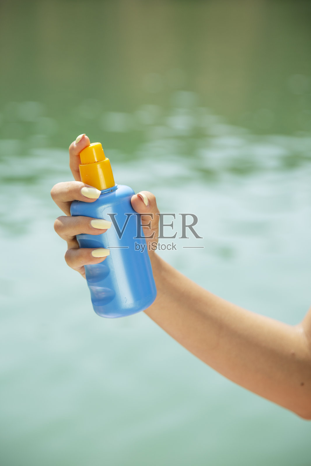 近距离喷洒防晒乳液的手照片摄影图片