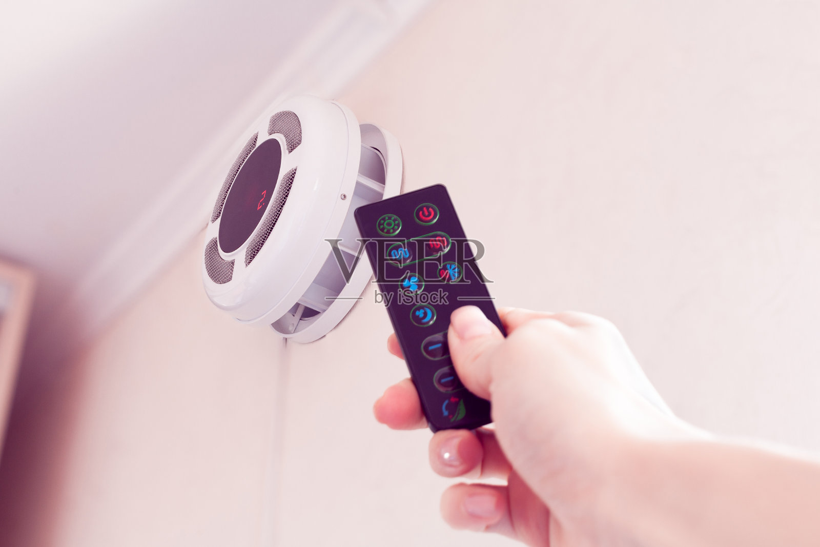 女用手通过遥控器打开室内空气清新器照片摄影图片