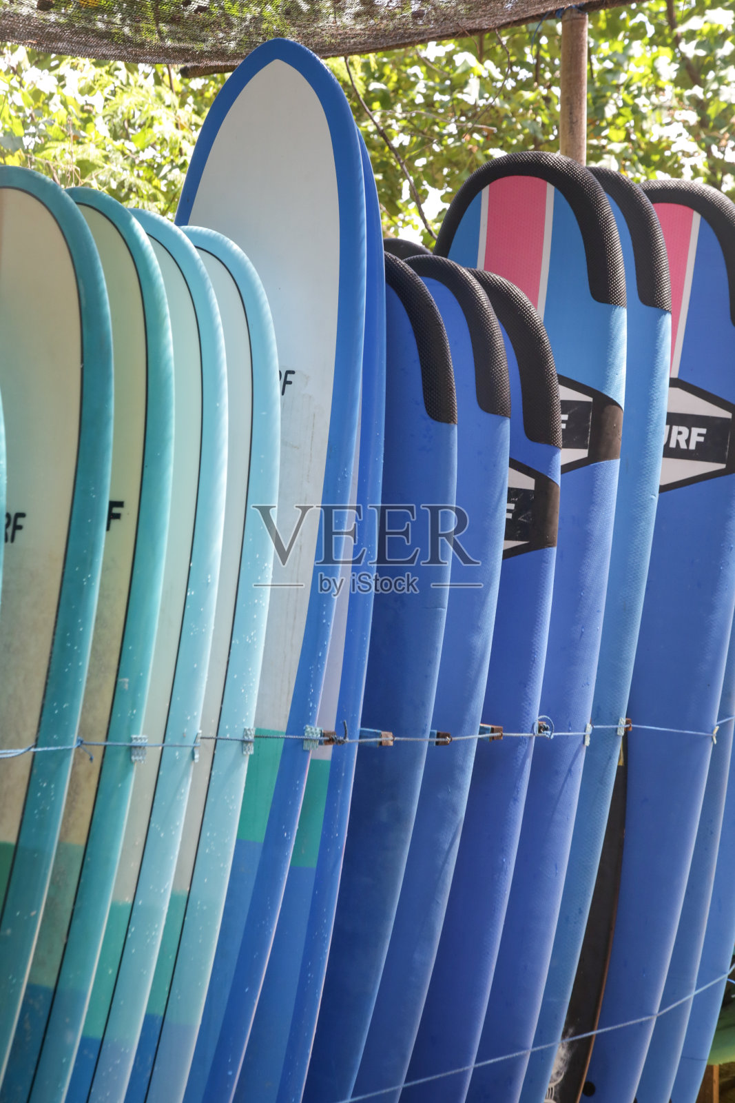 海滩上出租的冲浪板。冲浪营。照片摄影图片