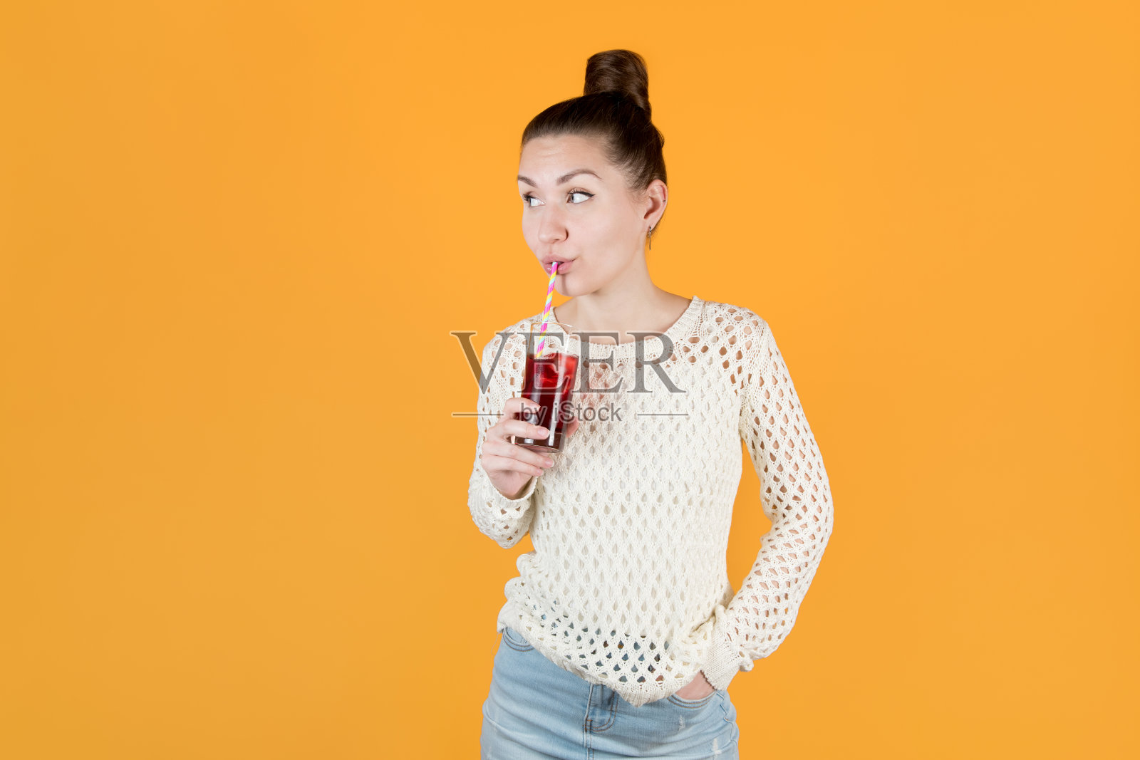 女孩用吸管喝冰镇果汁,看向远方照片摄影图片