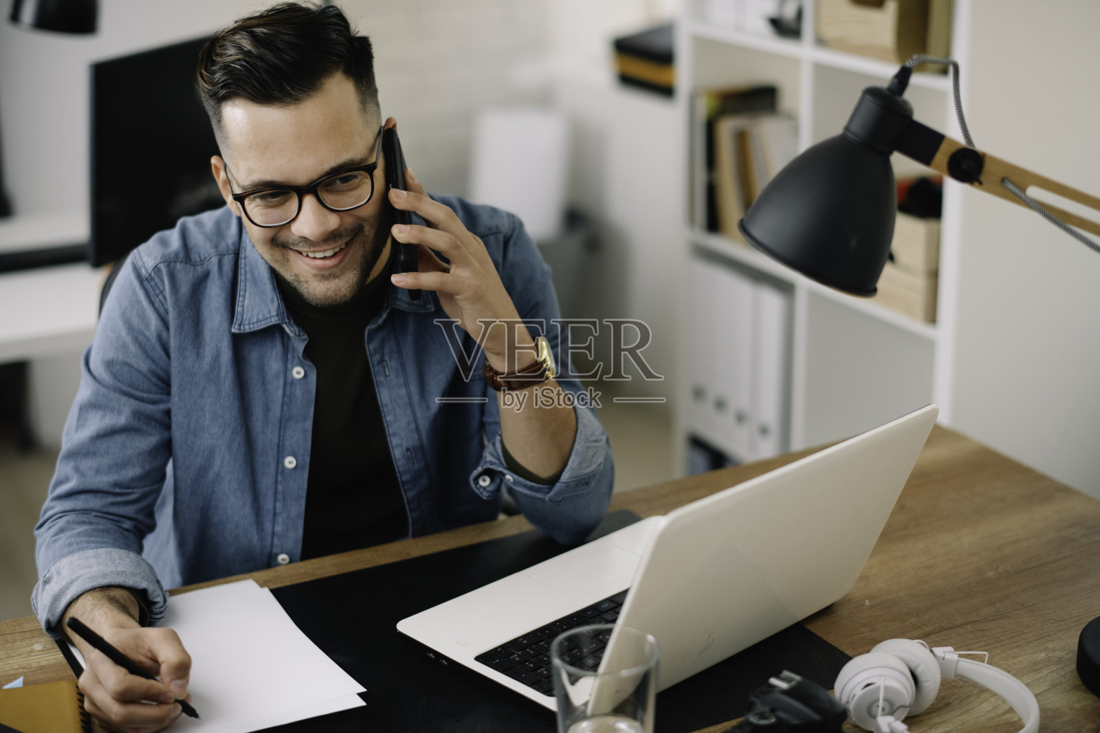 在办公室里打电话的商人。照片摄影图片