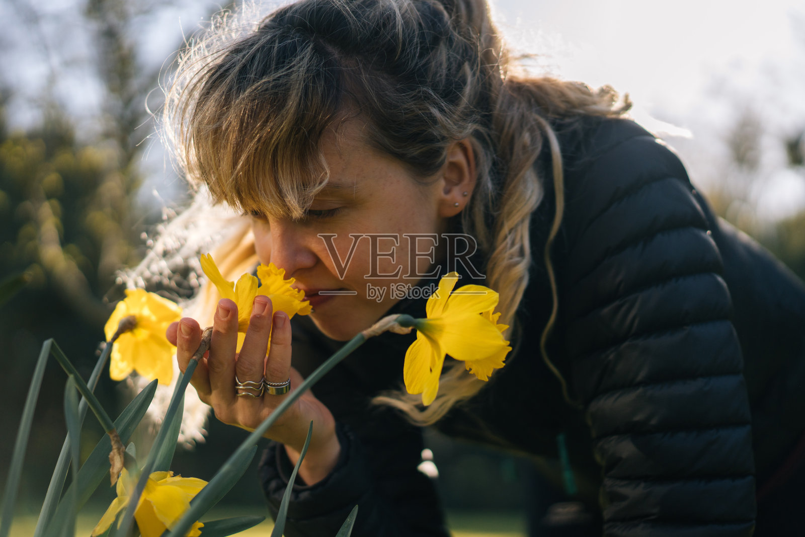 年轻女子俯身闻花香照片摄影图片